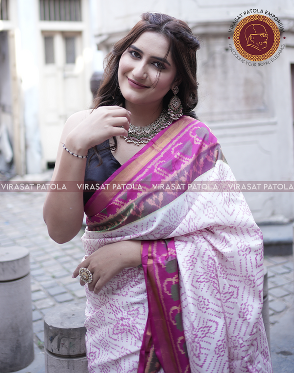 White pink bandhani patola saree with magenta border, draped over shoulder