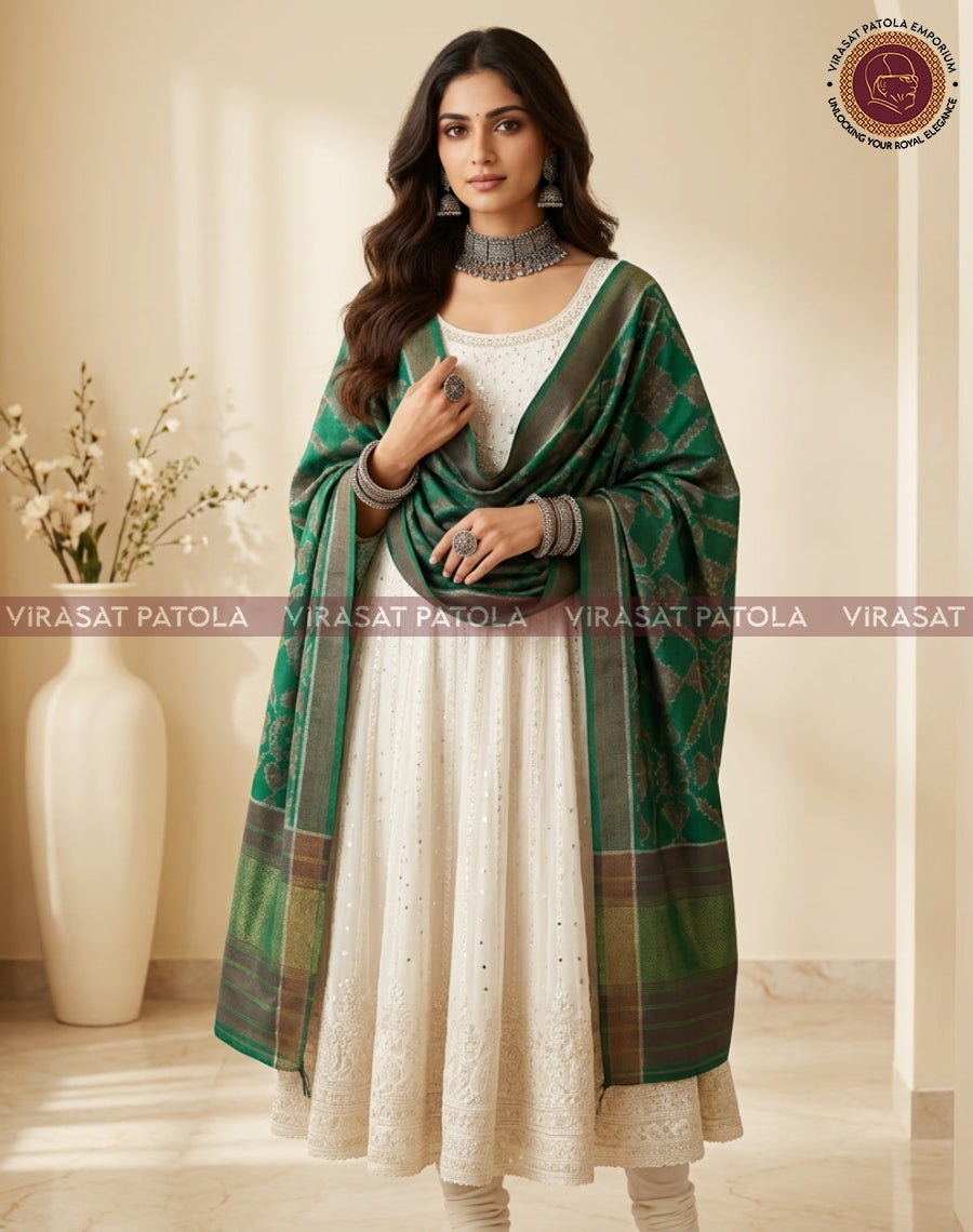 Green patola shawl draped over shoulders, patterned border visible.