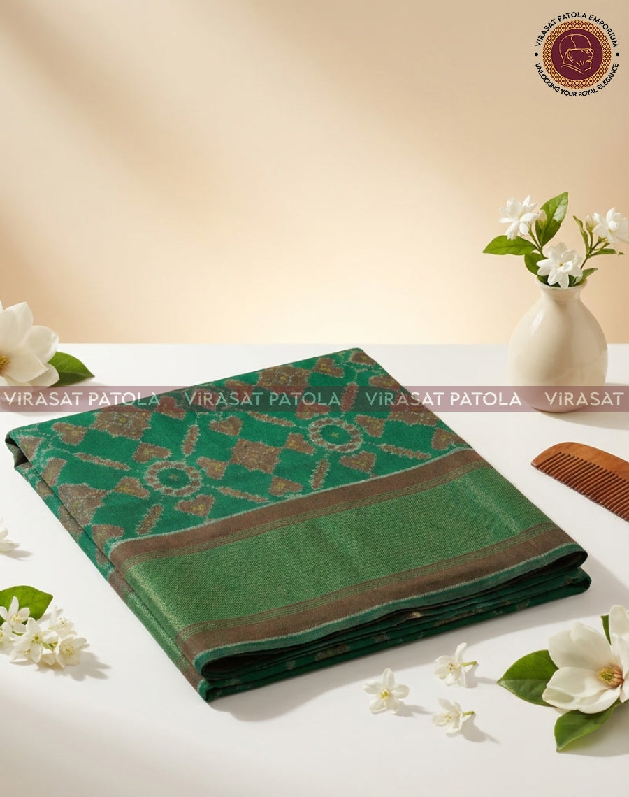 Green patola shawl with geometric motifs and woven border, neatly folded.