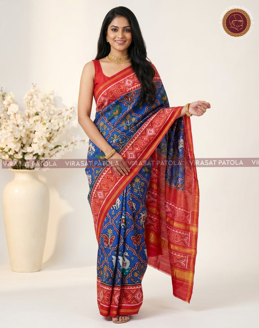 Blue patola saree with red-and-gold border, geometric motifs; paired with red blouse