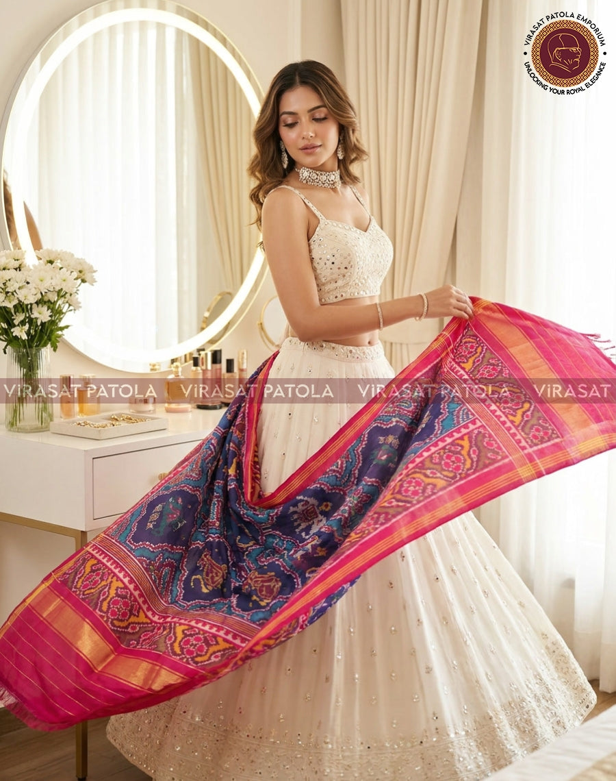 Blue patola dupatta with animal motifs, pink border, draped over arm