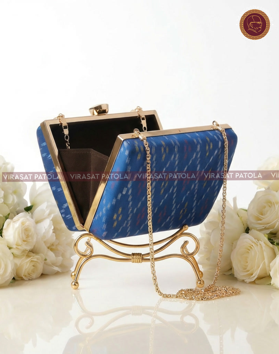 Blue patola bandhani clutch open showing dark interior and gold chain