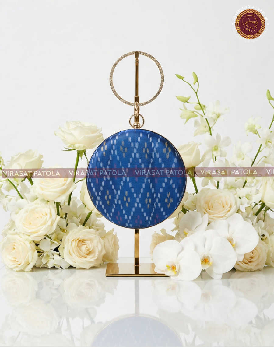 Blue round patola bandhani clutch with gold chain handle and clasp