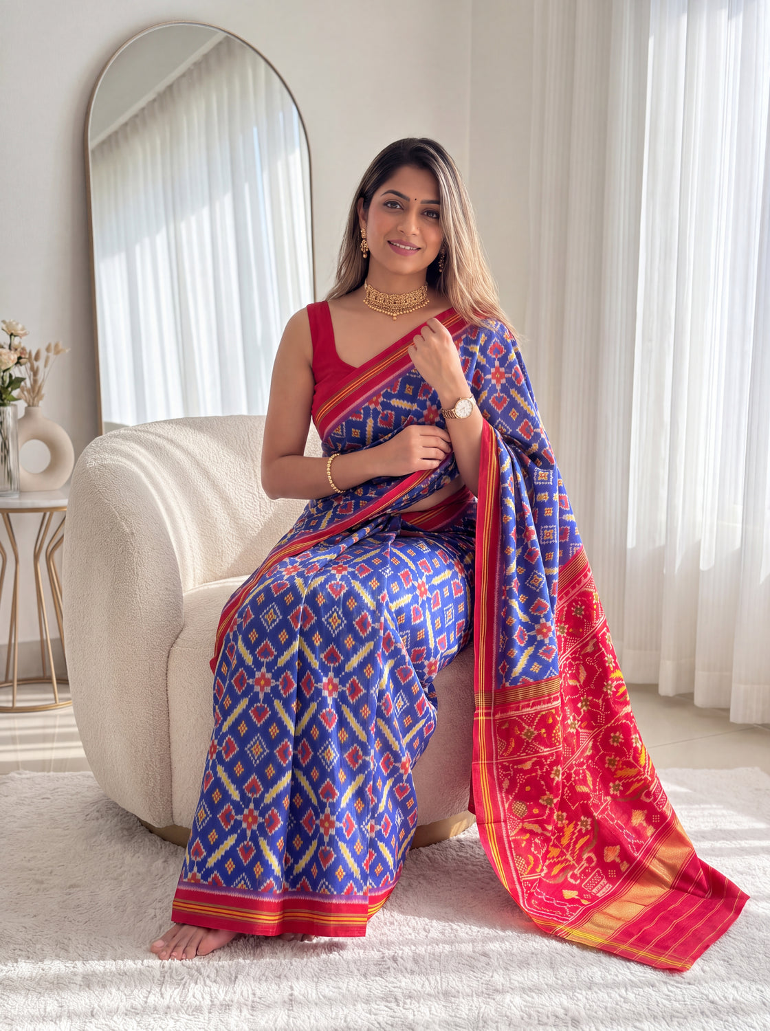 Blue and red patola saree with geometric weave and red-gold border, draped over shoulder