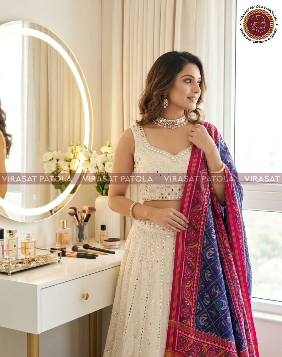Blue and pink patola-style dupatta with ornate border, draped on model's shoulder