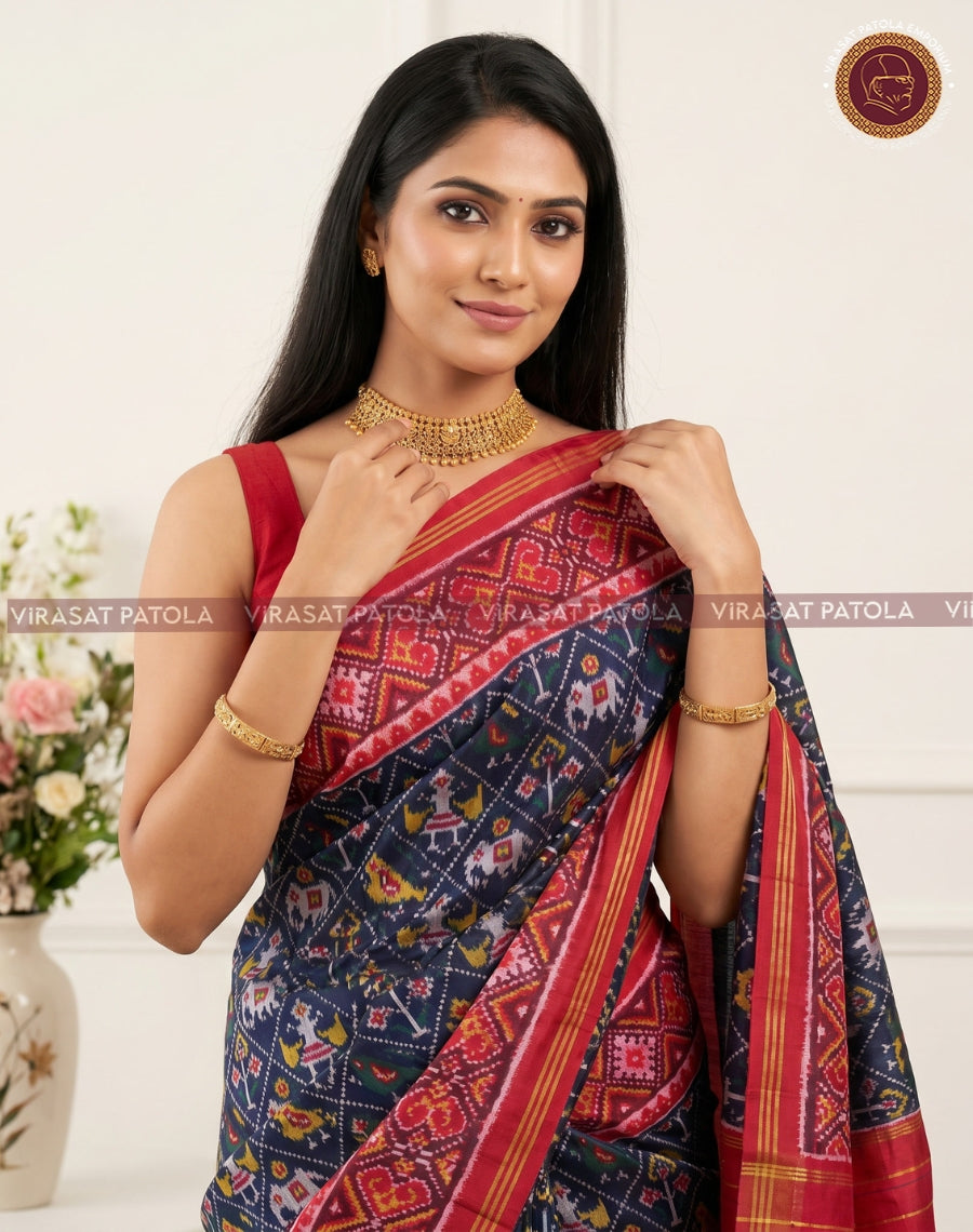 Dark blue Patola saree with red-pink border and gold zari, traditional weave