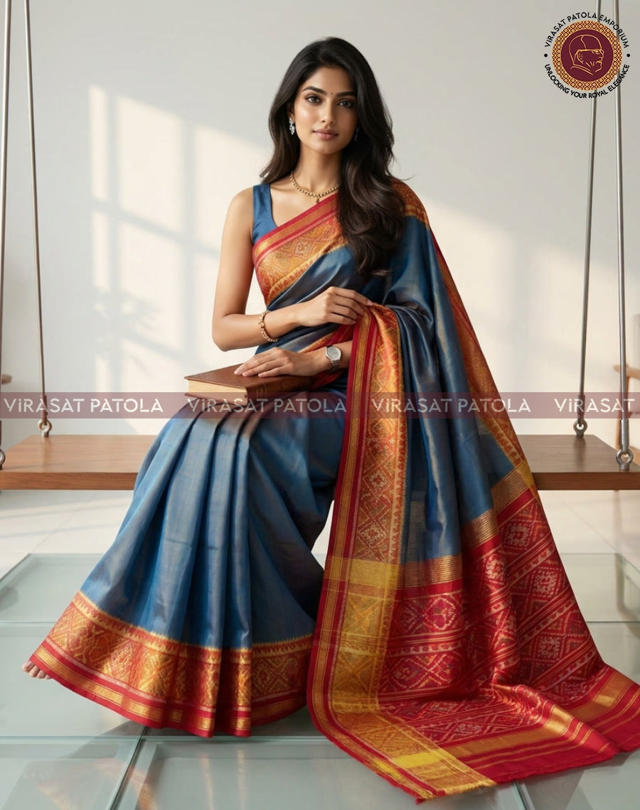Steel blue saree with broad red and gold woven border, draped with pallu