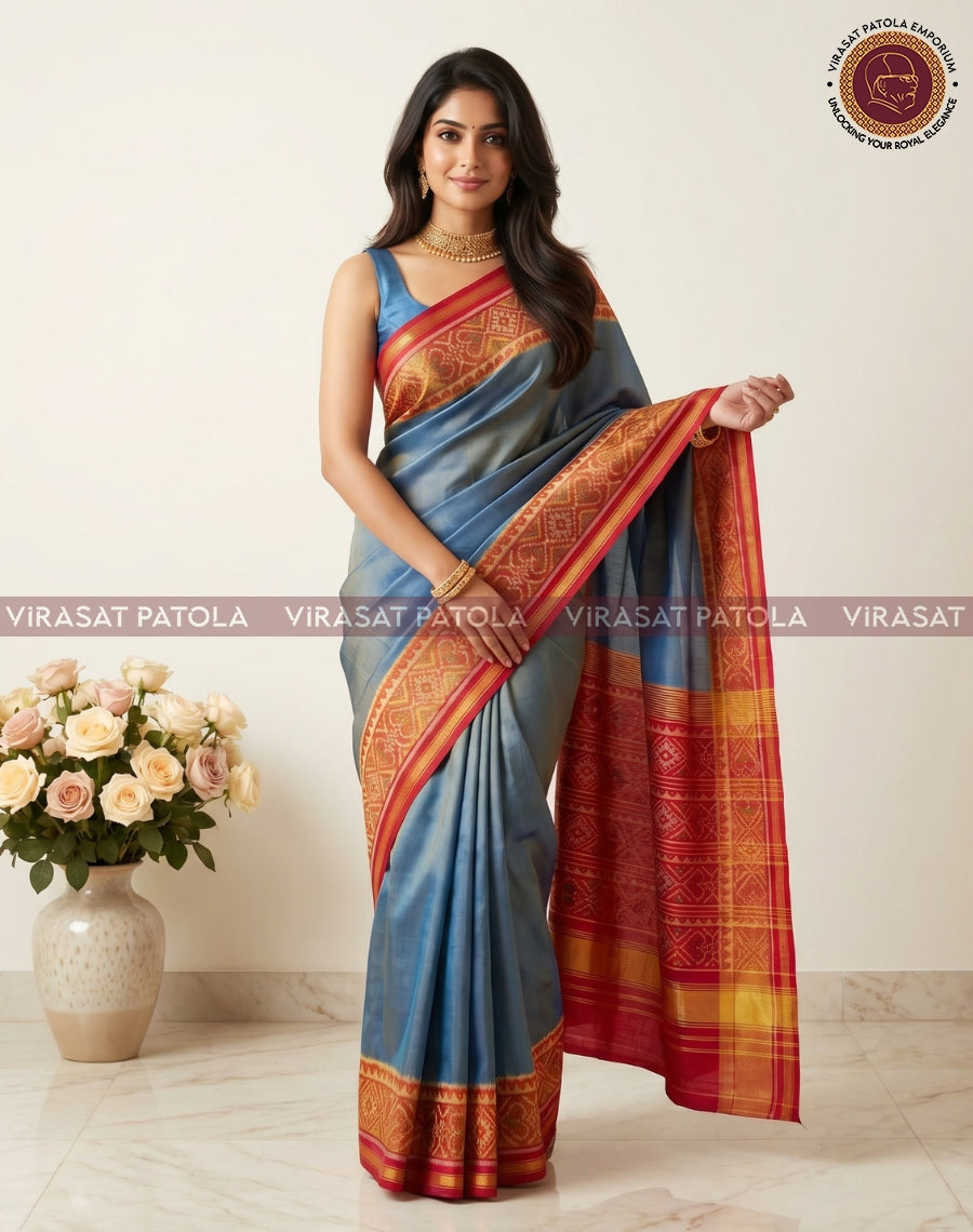 Steel blue saree with red-gold border, pallu held to show woven detailing