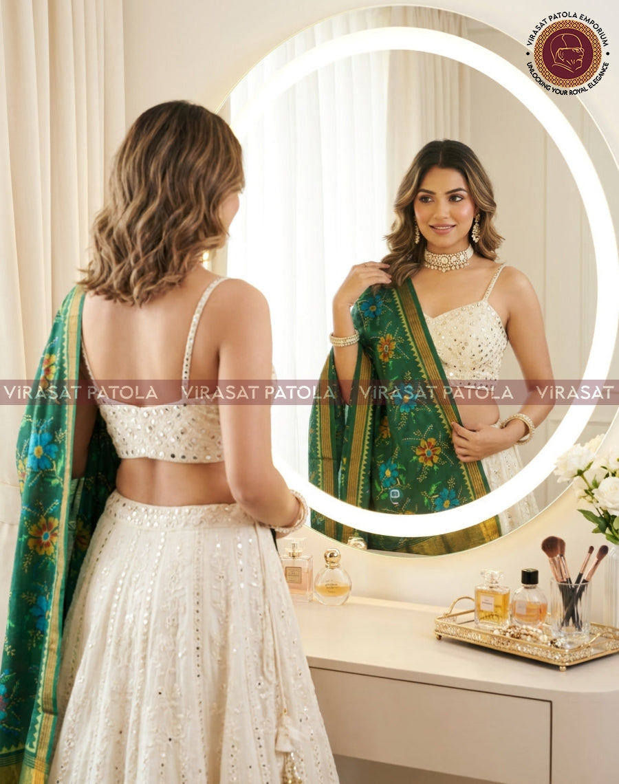 Green floral silk dupatta with gold border, draped over cream outfit back
