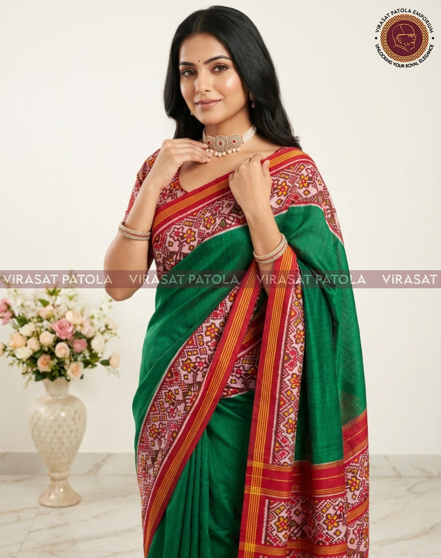 Dark green patola border saree with red and gold patterned pallu, draped on model