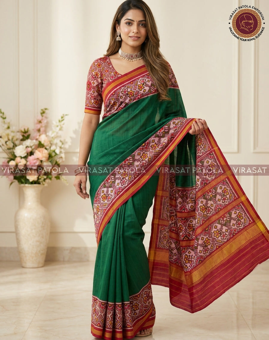 Dark green saree with red patterned pallu and gold border, model holding drape