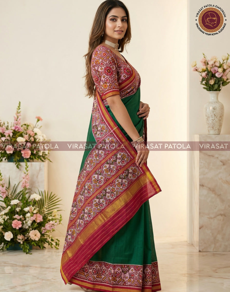Dark green saree with red patterned border and gold trim, side view on model