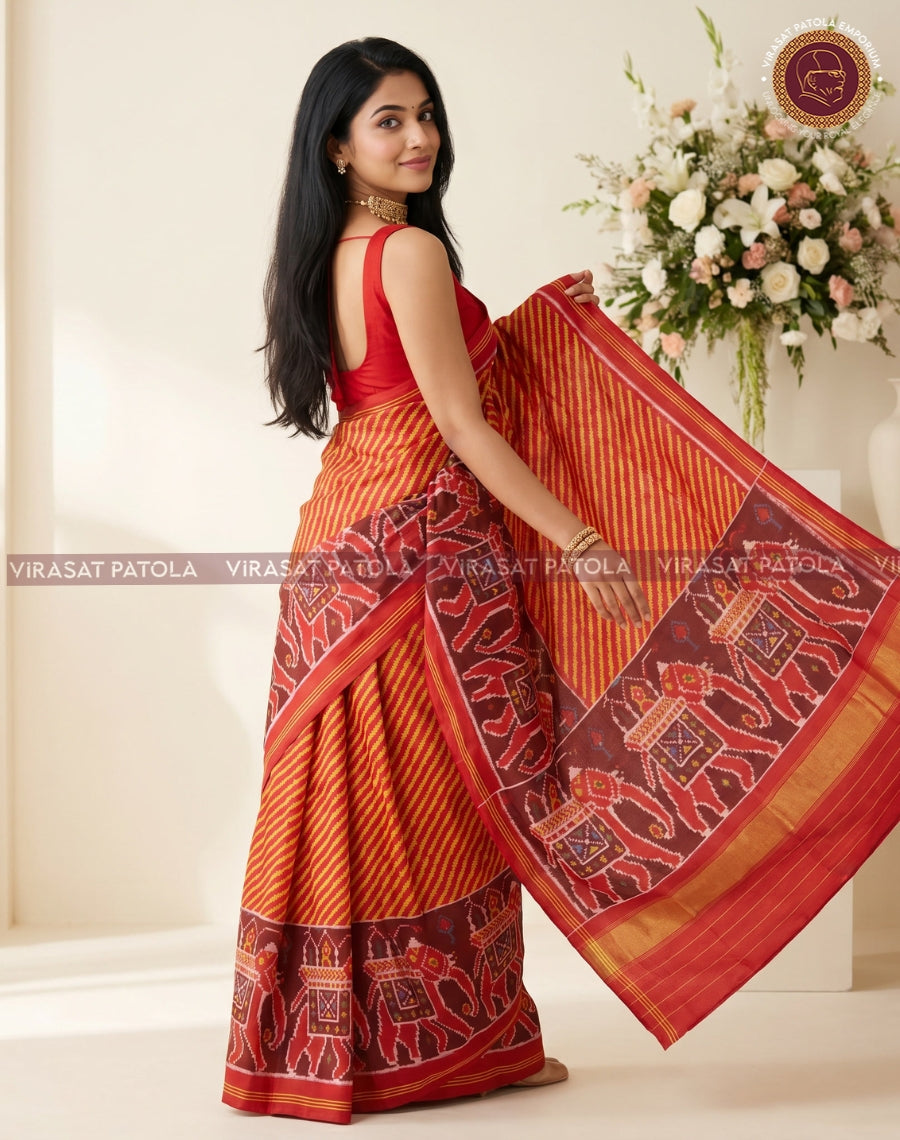 Rust-orange saree drape with maroon border, gold trim, and repeating geometric motif panels