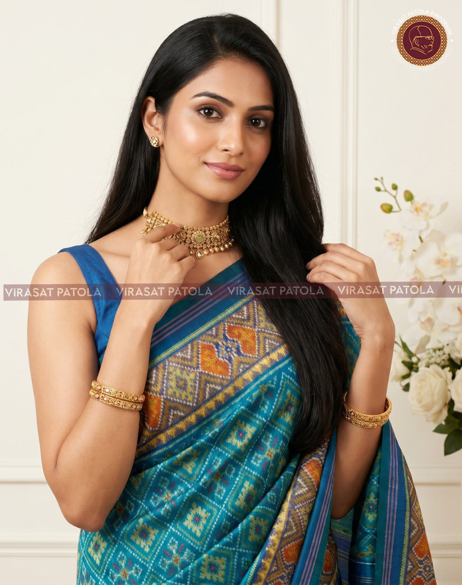 Sky blue patola sari with geometric motifs and gold-orange border on pallu