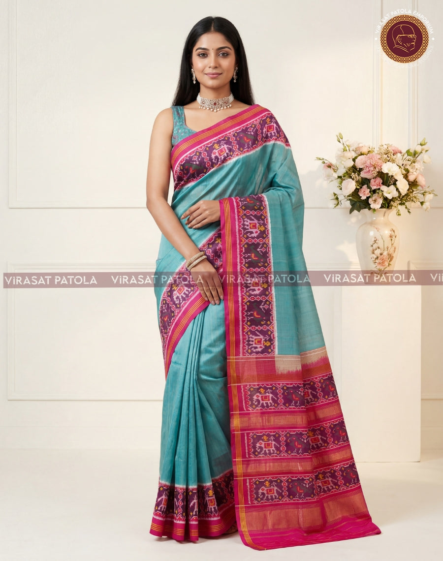 Teal saree with wide magenta border, patterned pallu and zari-trim accents