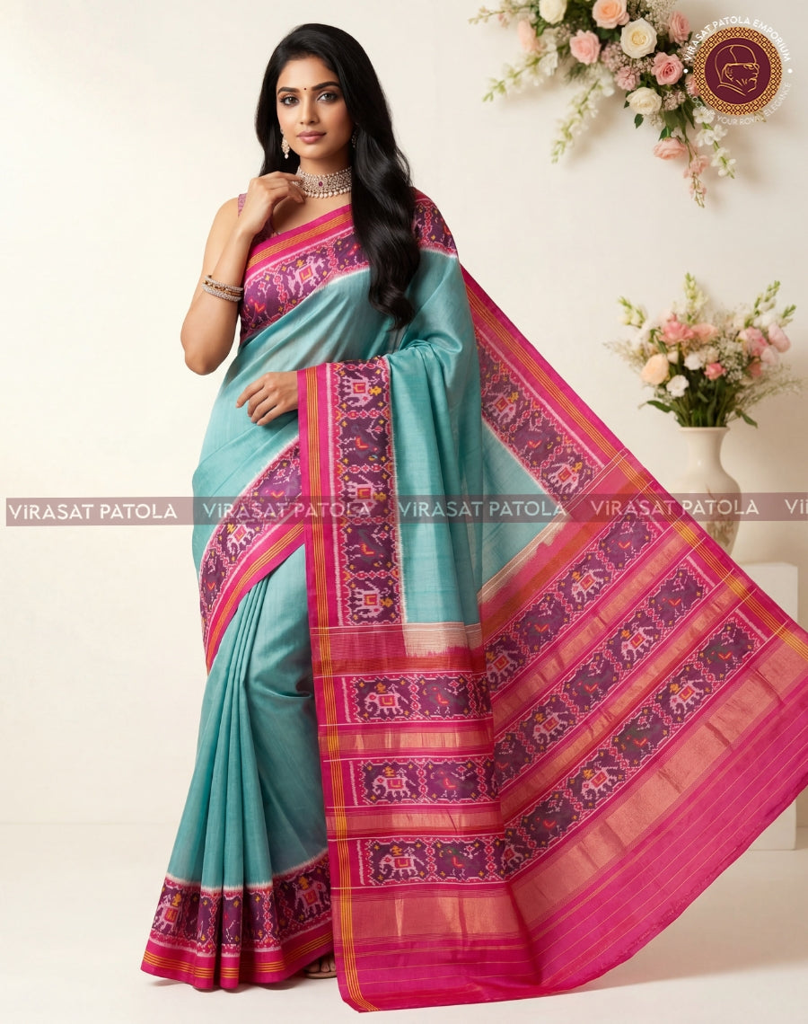 Teal saree with bright magenta border, woven motif panels and pallu drape