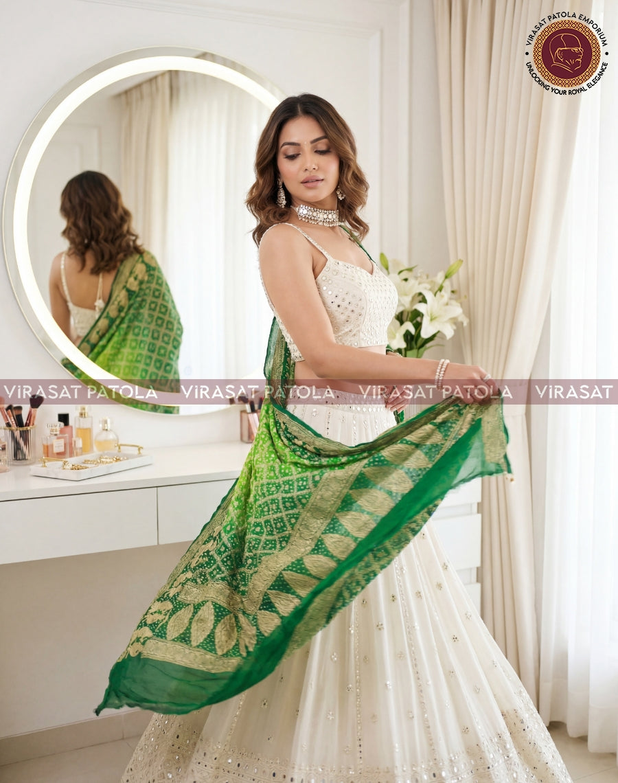 Green bandhani dupatta with wide gold border, draped across the torso