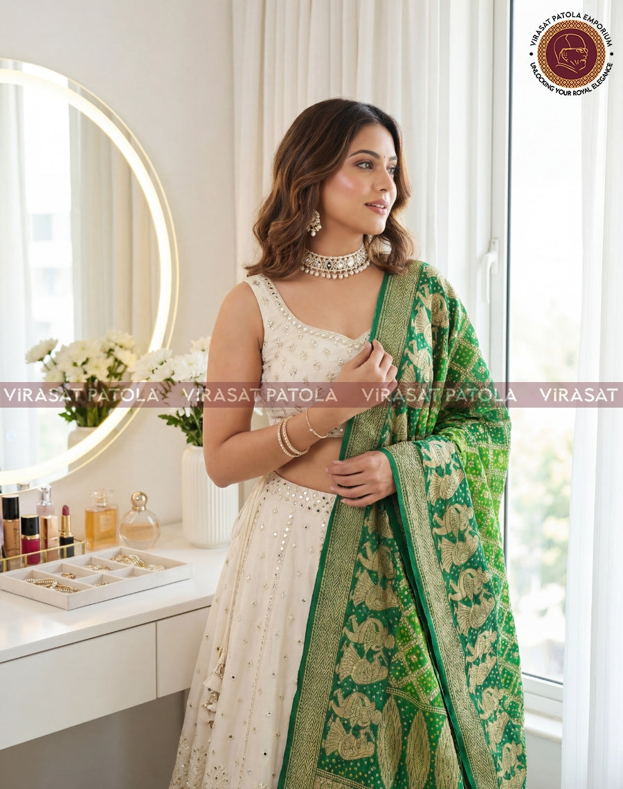 Green bandhani dupatta with gold border, held over the shoulder