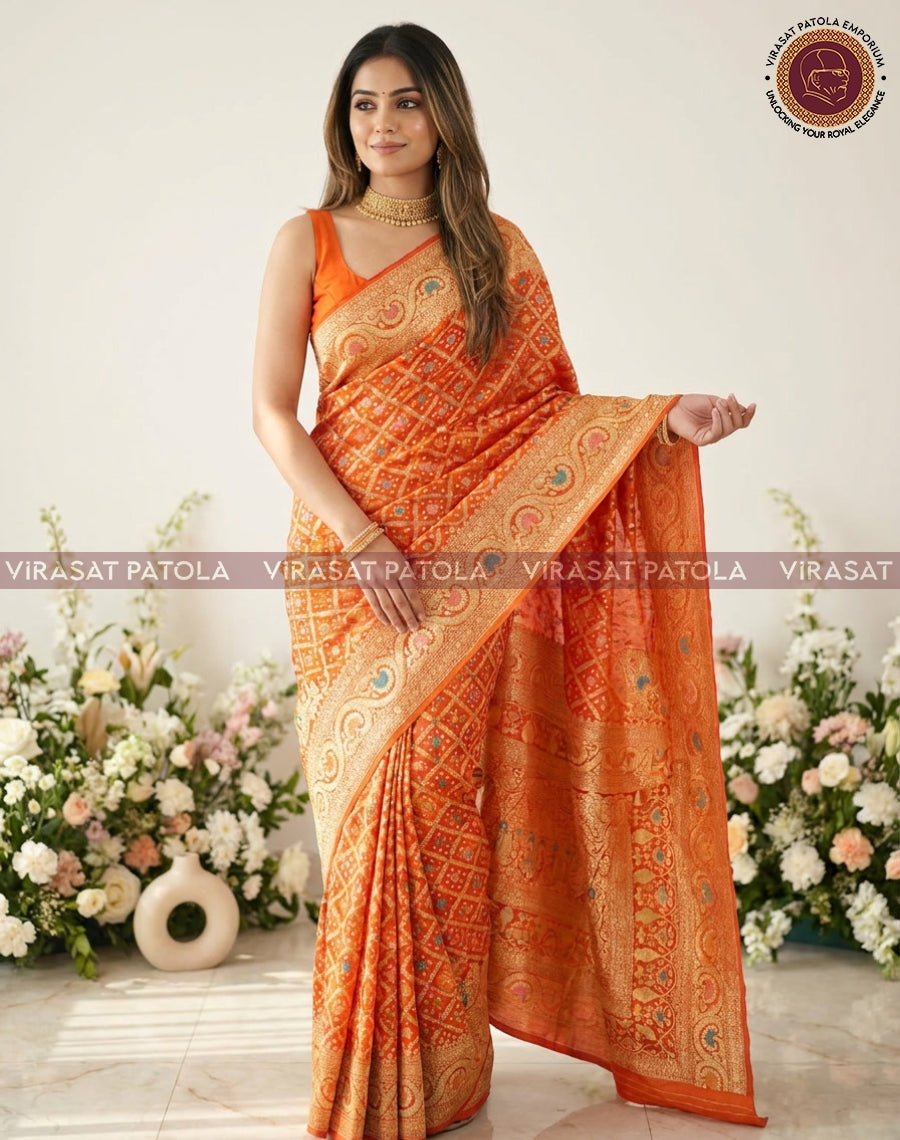 Orange saree featuring geometric bandhani print and ornate pallu with teal accents