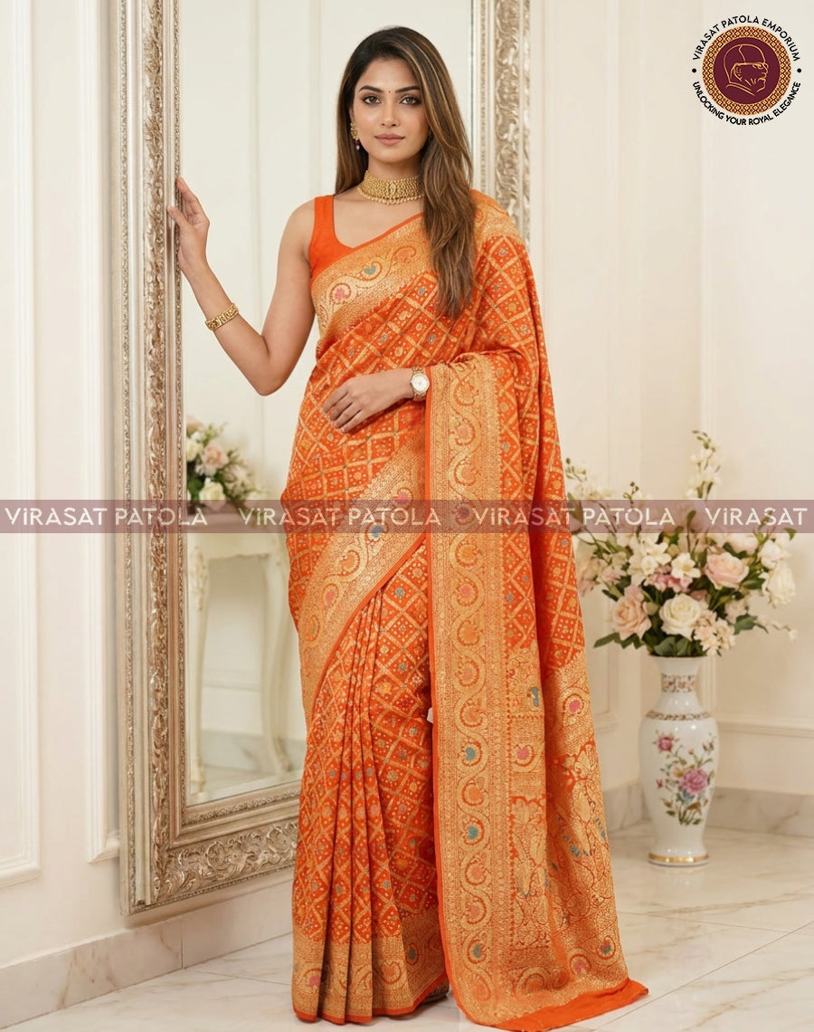Orange bandhani saree with embellished pallu and contrast cream-gold woven border