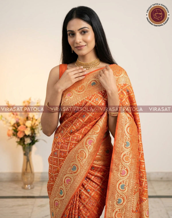 Orange bandhani saree with gold-toned paisley border and draped pallu