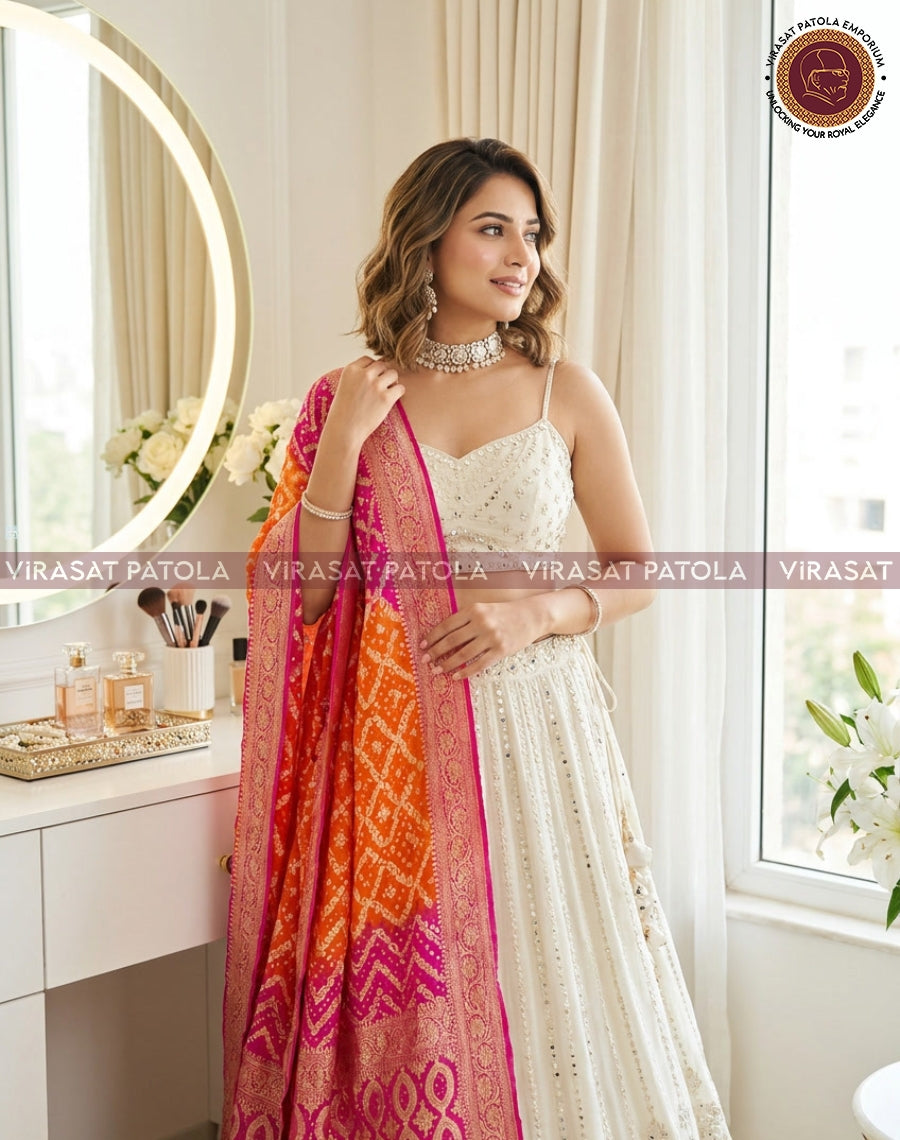 Pink-orange bandhani dupatta with geometric pattern and magenta border, held up