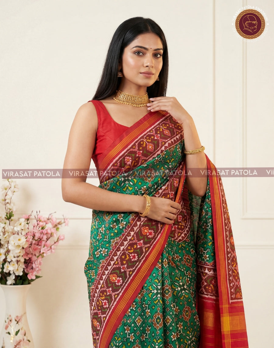 Red, green traditional patola saree with patterned pallu and golden border