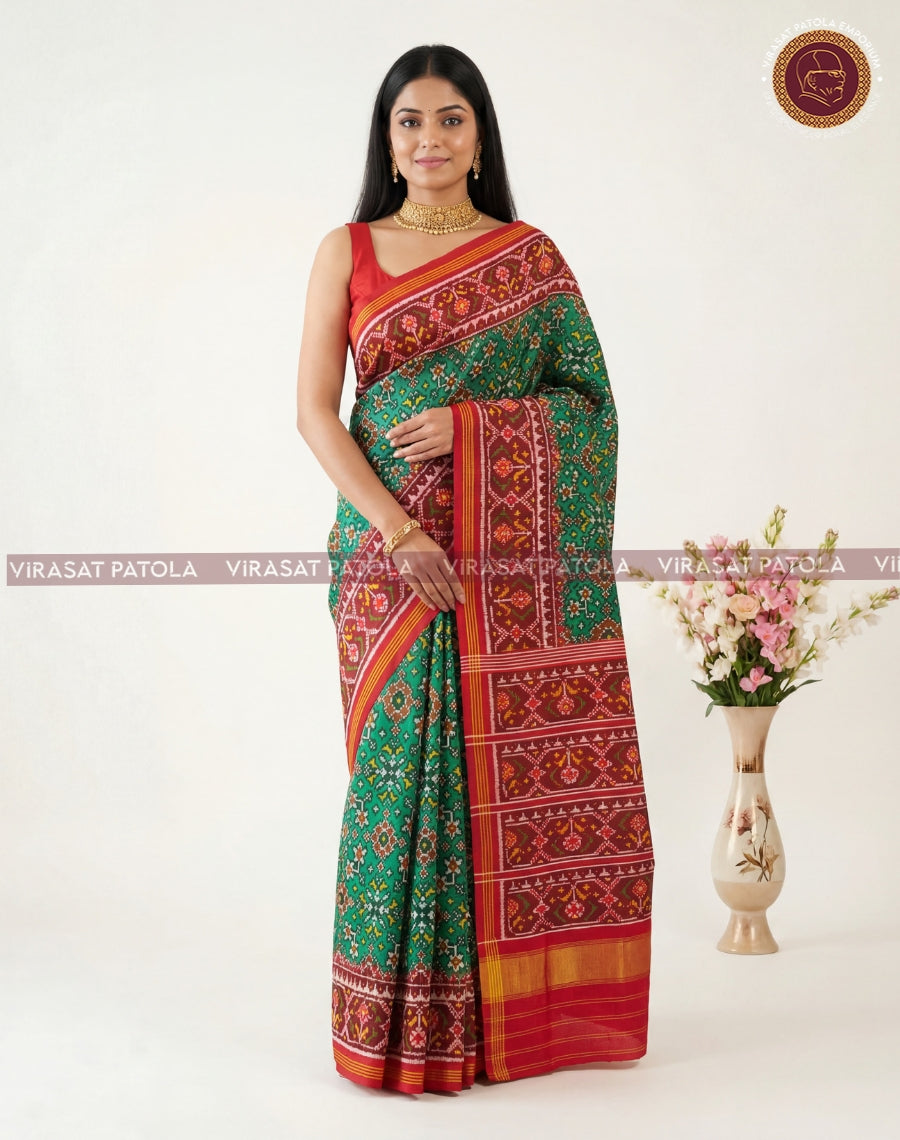 Green-red patola saree with striped border, ornate bands, and patterned pallu