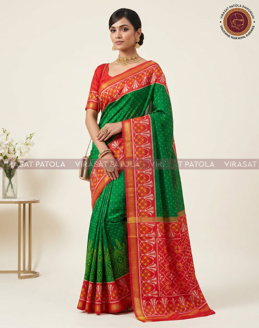 Green saree with red-orange patola border, zari-style details, and pleated fall