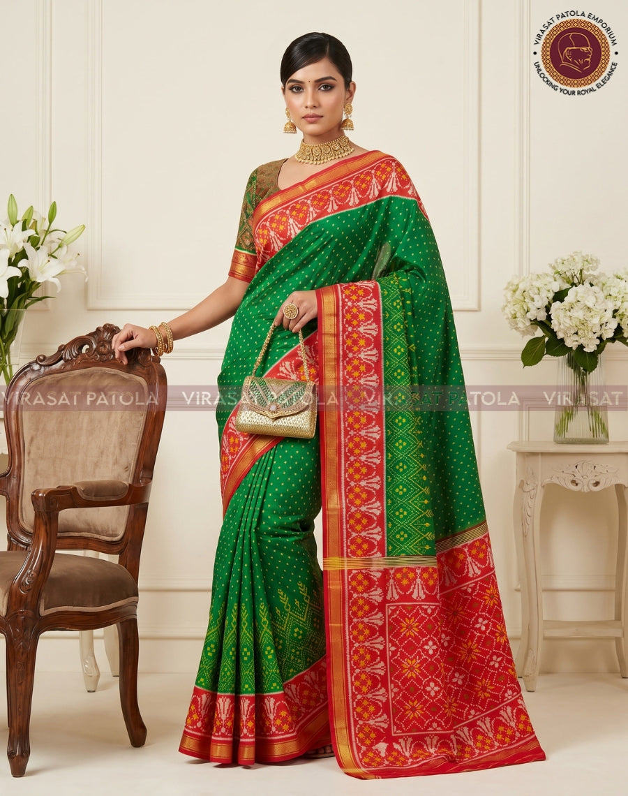 Green patola saree drape with wide red patterned border and gold trim