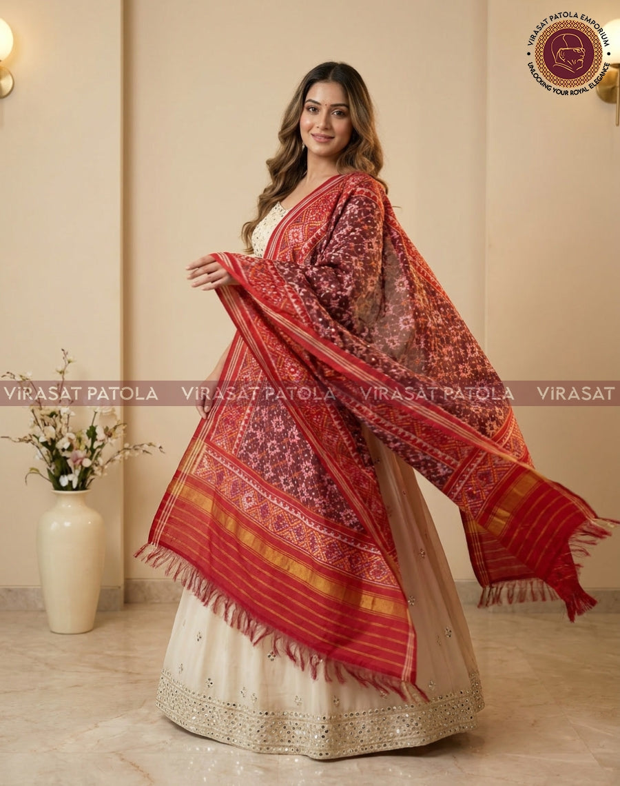 Maroon red patola dupatta draped over shoulder, detailed motifs with gold border and fringe