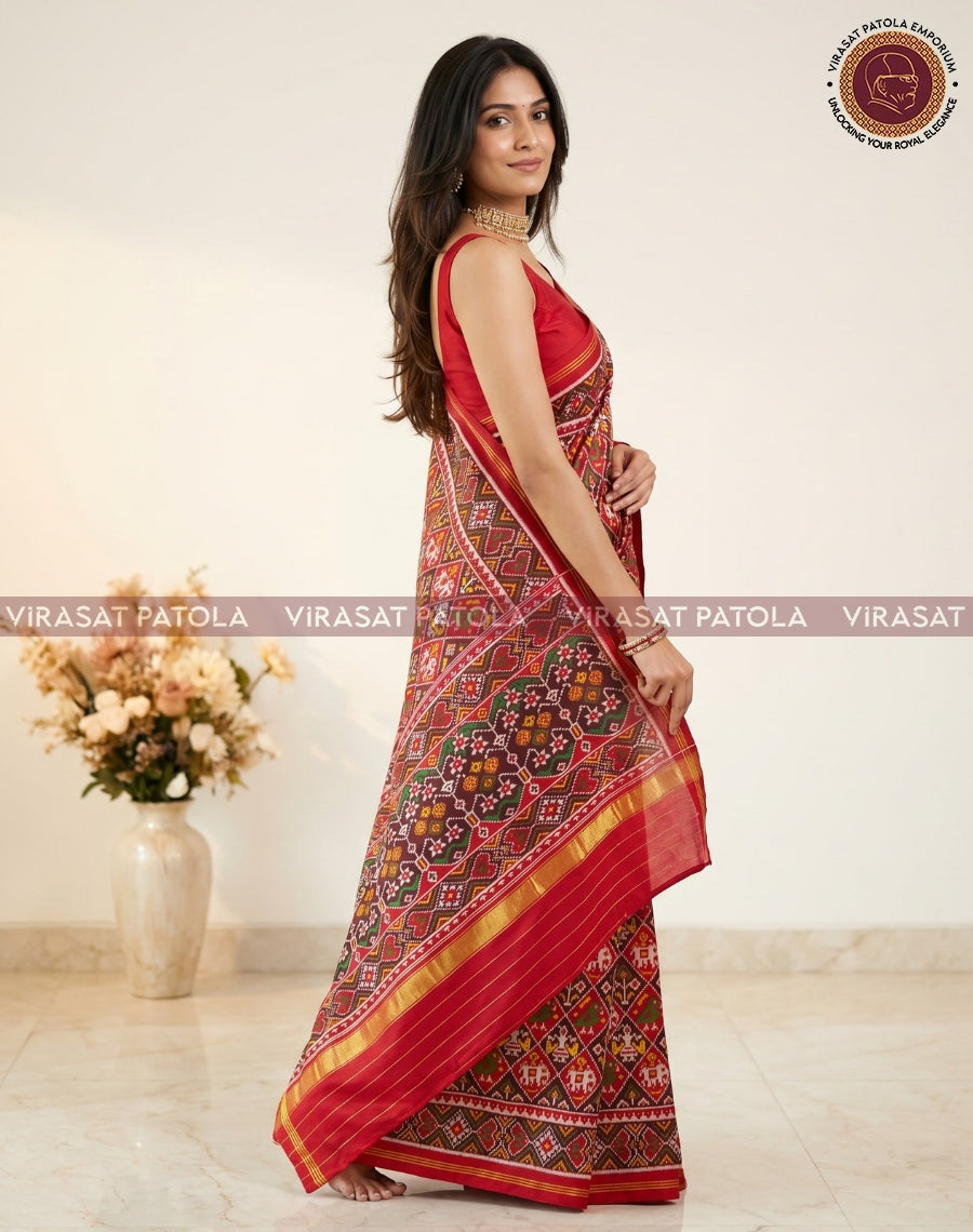 Maroon patola saree draped over shoulder, multicolor square motifs and gold border