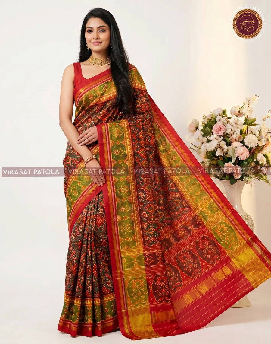 Maroon patola saree with wide pallu showing gold-green pattern and red woven border