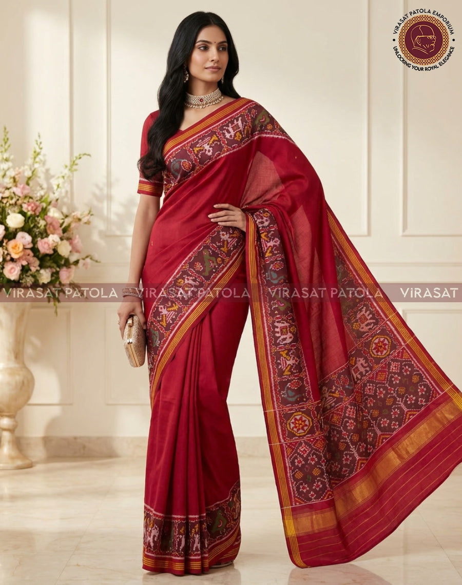 Maroon saree with multicolor patola motifs and gold border, draped in traditional style