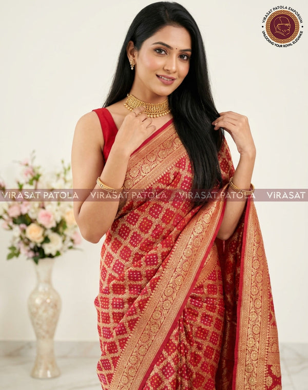 Red bandhani georgette saree with gold woven border and patterned pallu, draped.
