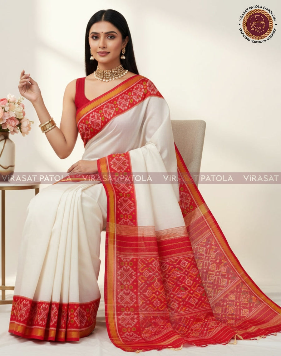 White saree with red geometric Patola border and gold-yellow piping on hem