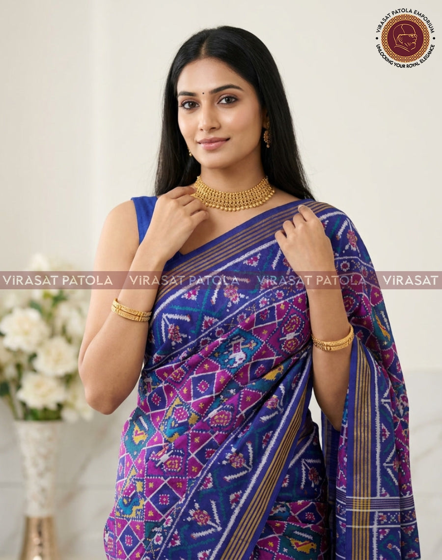 Royal blue patola saree with colorful floral diamond motifs and gold-striped pallu border