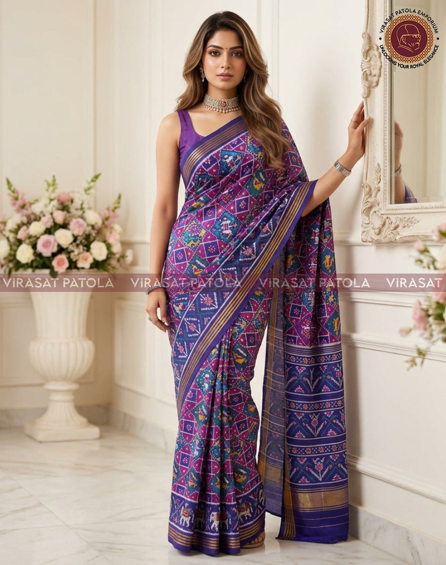 Royal blue patola saree with magenta pattern panel and wide gold border on pallu