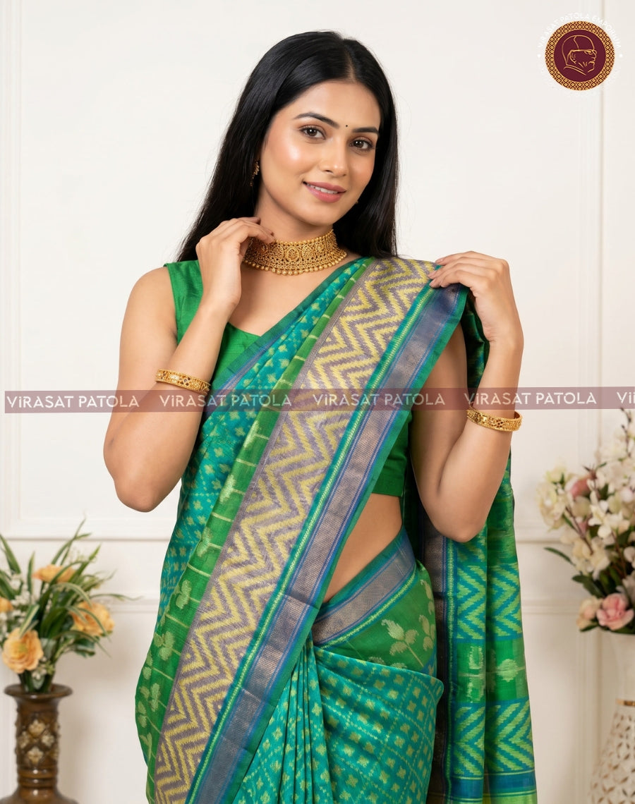Fancy patola saree, green body with zigzag pallu border and gold accents