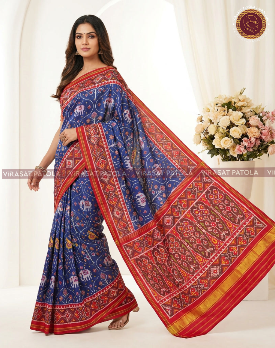 Blue saree with red geometric motifs and wide border, draped with pallu