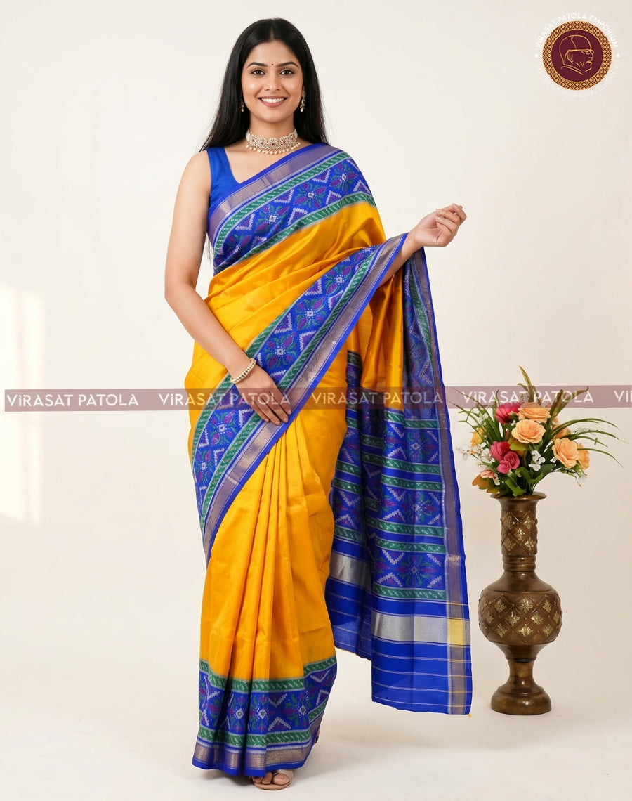 Yellow traditional patola saree with blue patterned border and contrast blouse