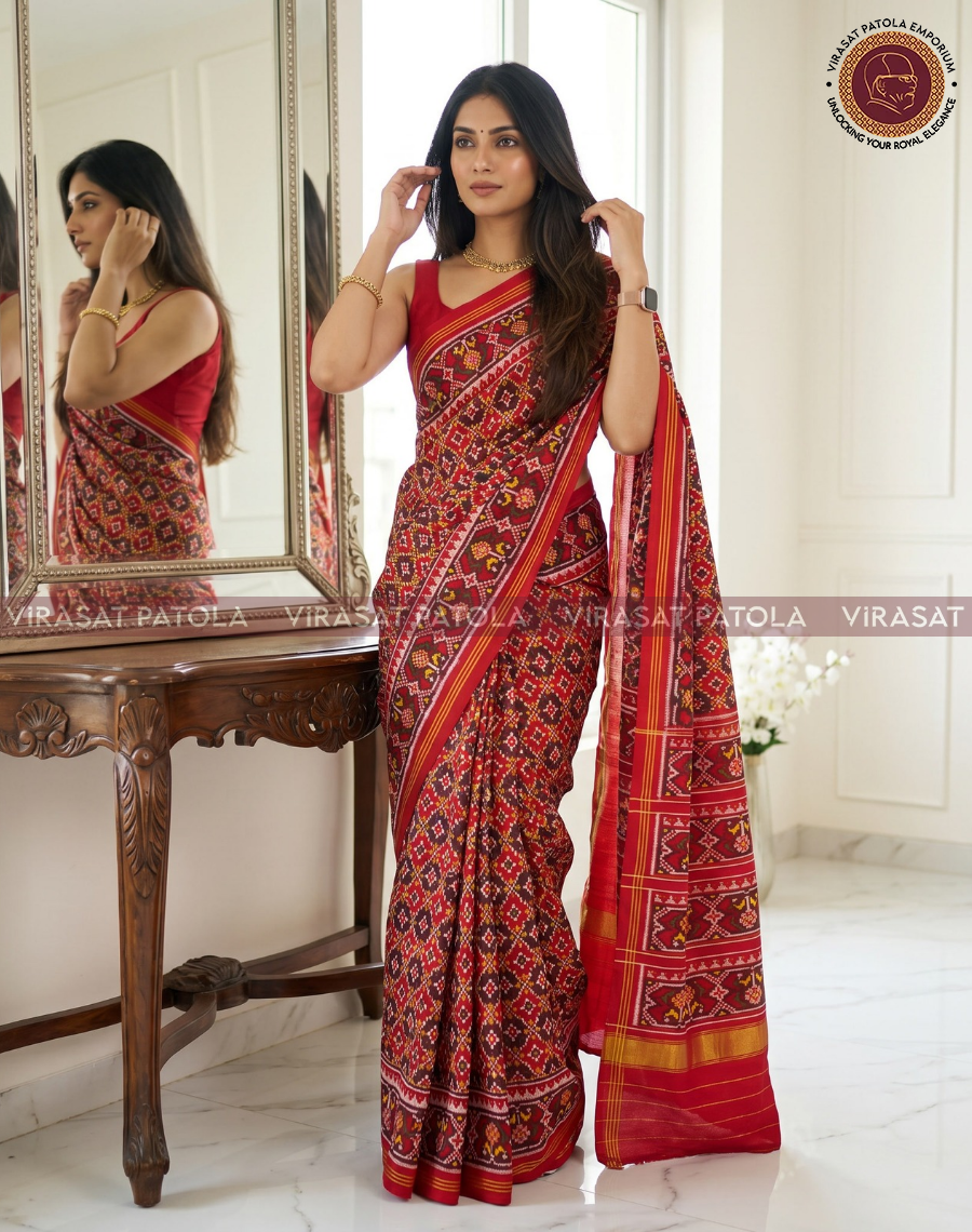 Red patola saree with geometric motifs and gold-red border, draped on model