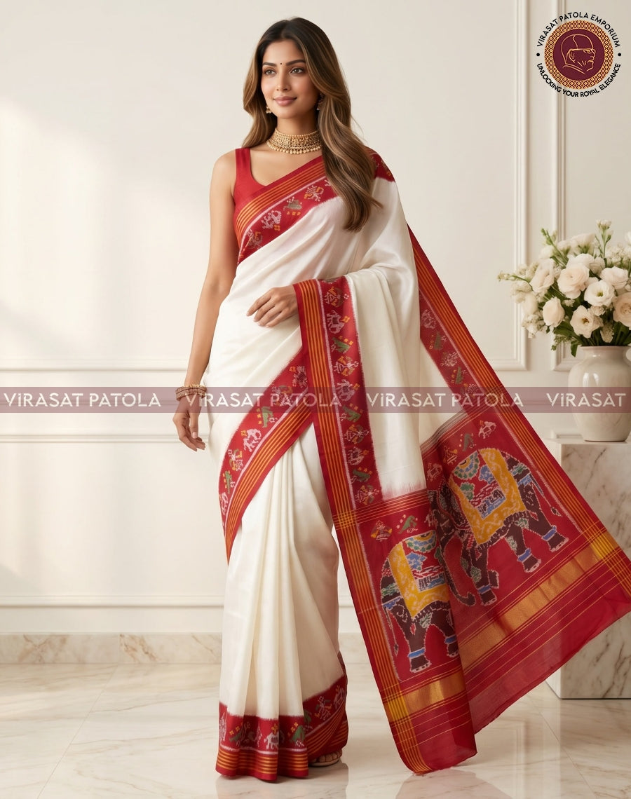White saree with red pallu featuring elephant motifs and striped border