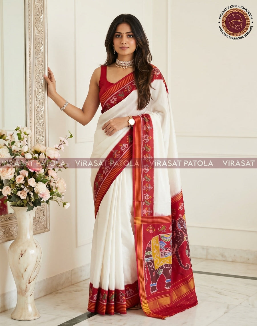 Traditional white saree with red border, gold trim, and elephant motif pallu