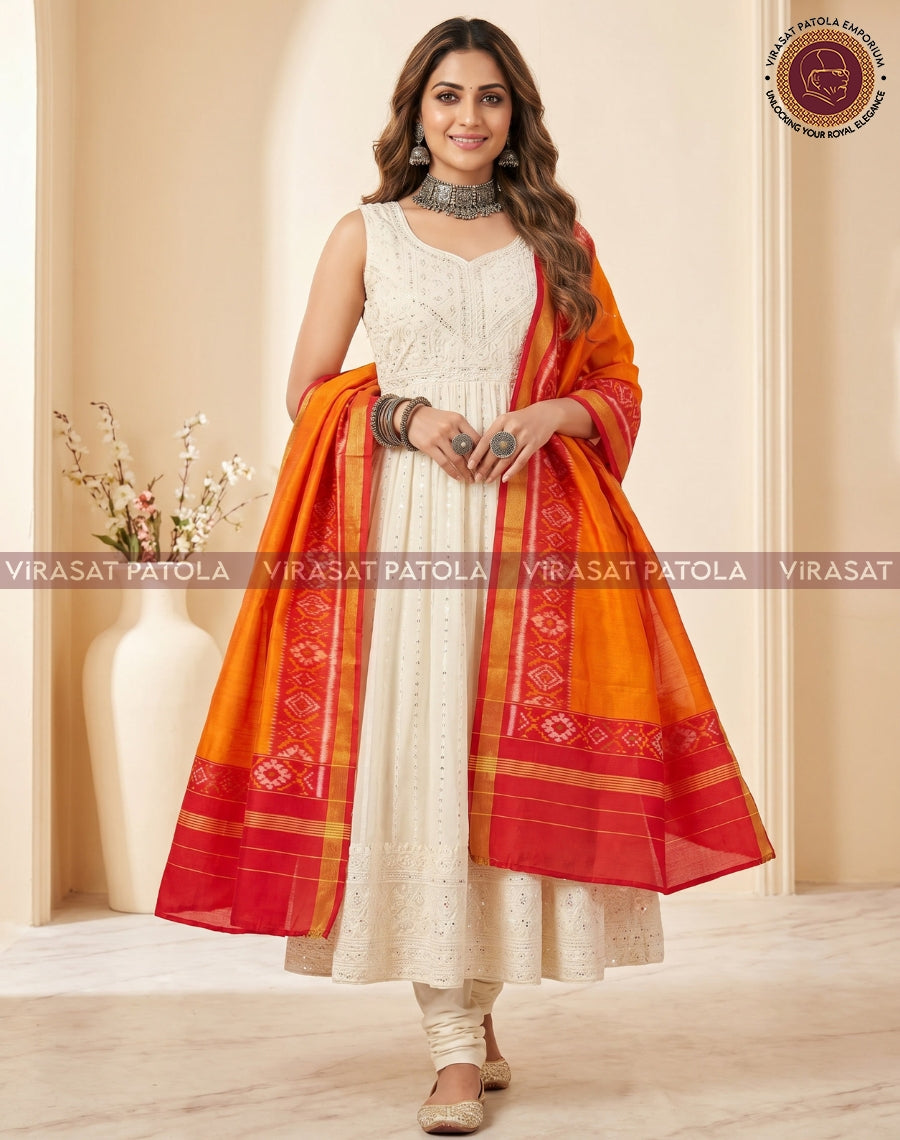 Red and orange patola dupatta with gold border, held on both sides over a white dress